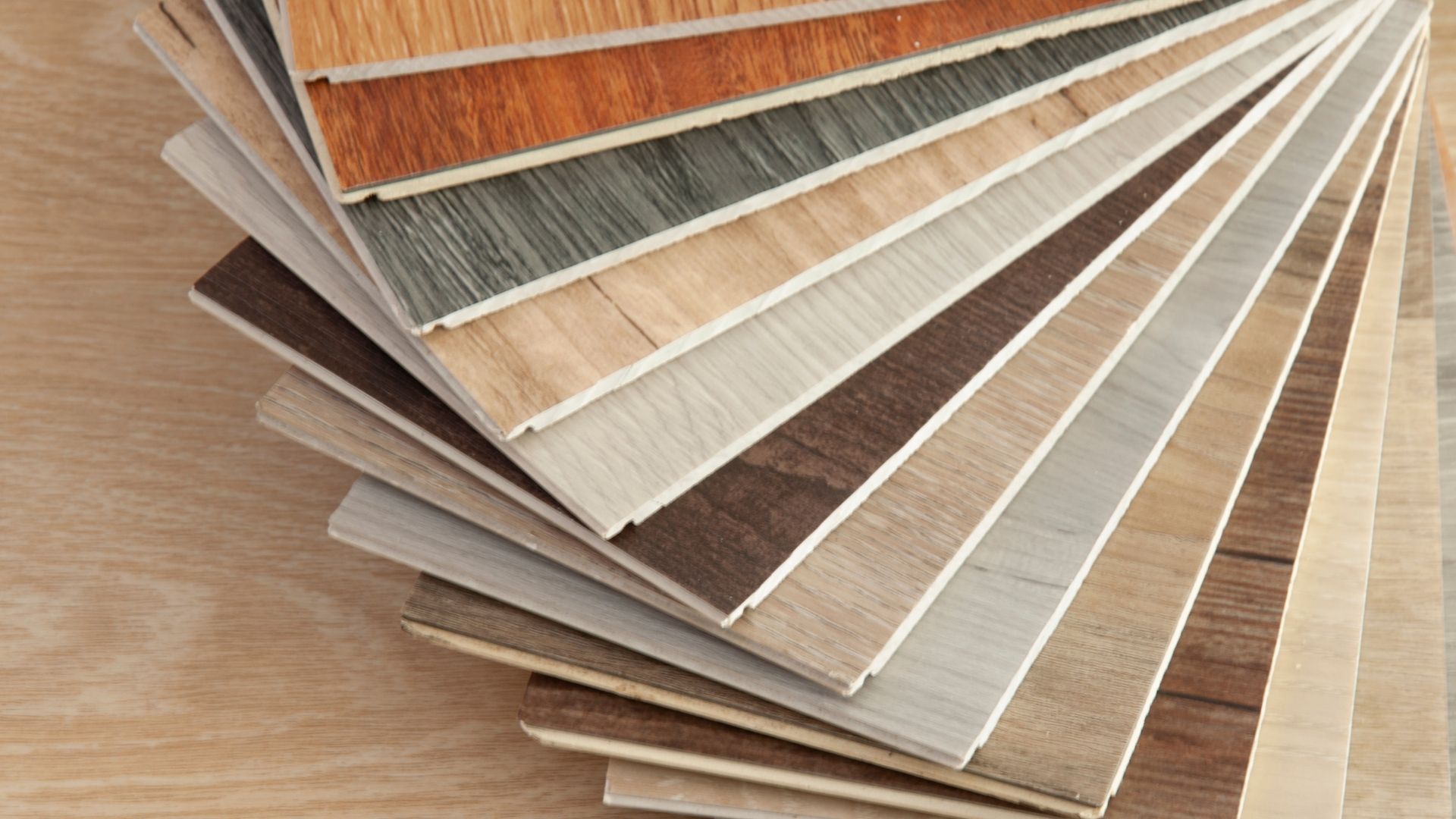 Fanned samples of luxury vinyl plank flooring in different wood tones